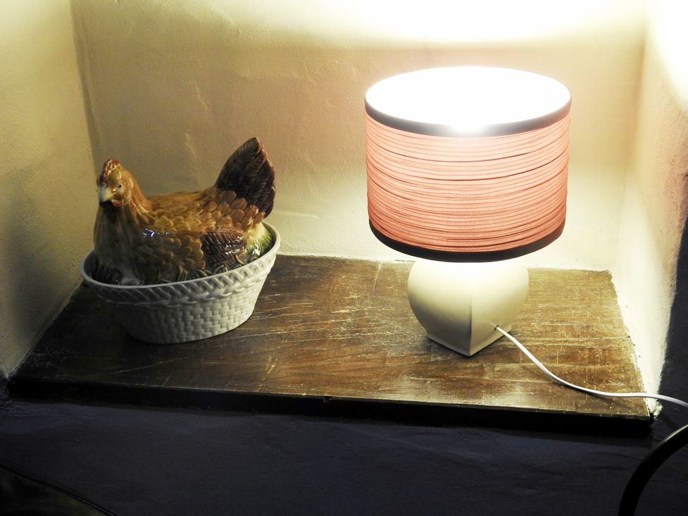A lamp and a chicken sculpture on a wooden shelf at Butterslade 