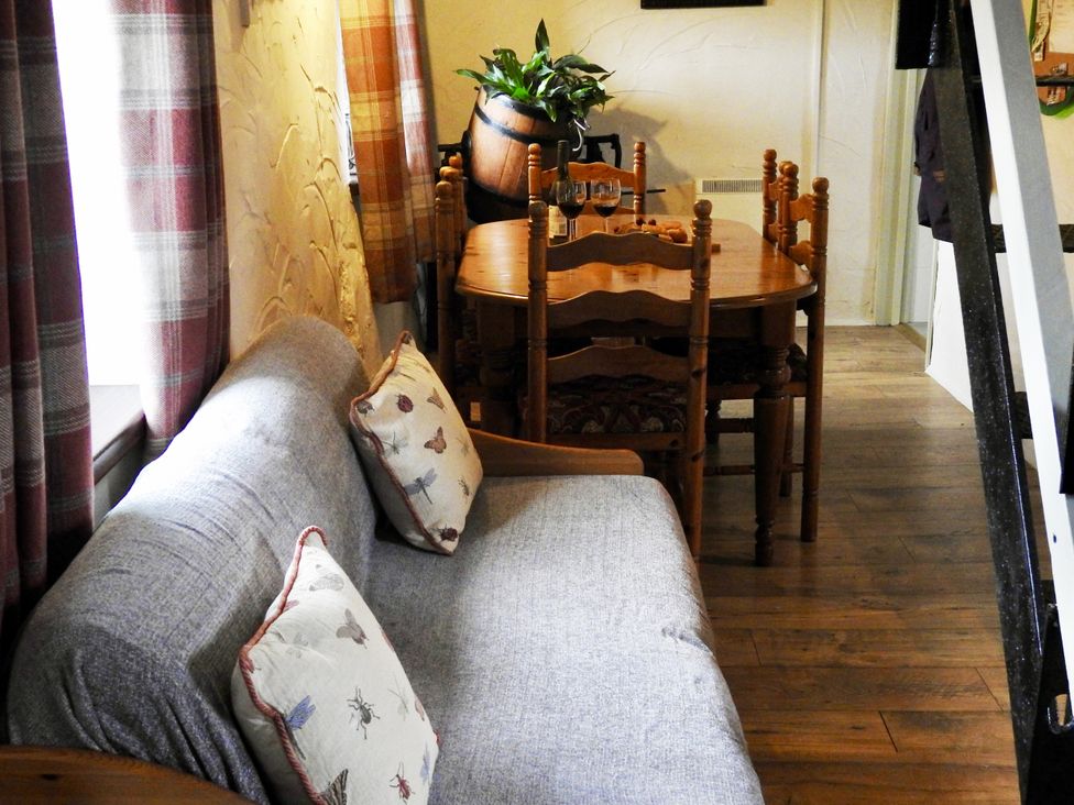 A living room with a sofa and dining table at Butterslade