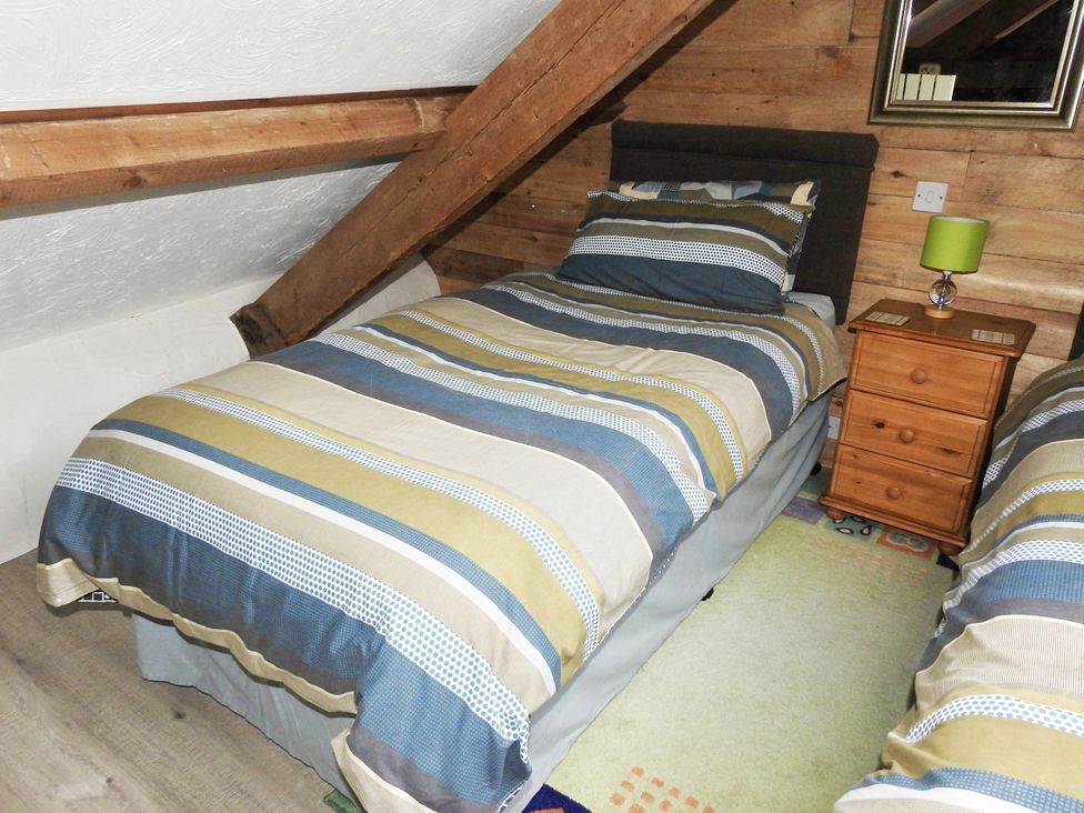 A bedroom with two beds and a nightstand at Butterslade