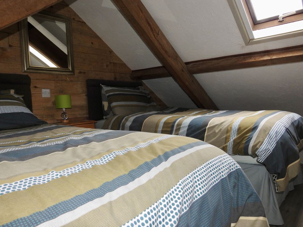 A bedroom with two beds and a lamp at Butterslade