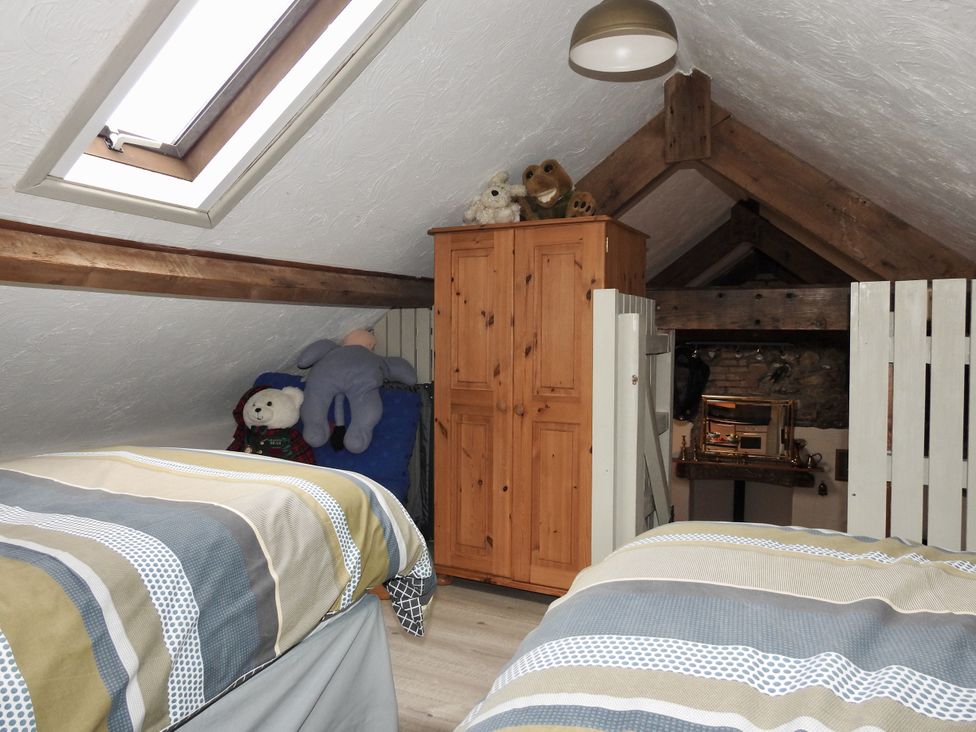 A bedroom with two beds and a wardrobe at Butterslade