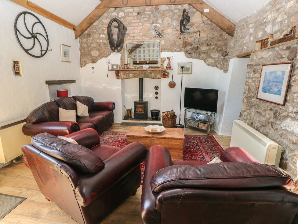 A living room with sofas and a fireplace at Butterslade in Port Eynon
