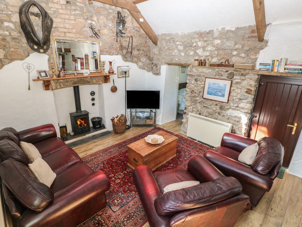 A living room with a fireplace and television at Butterslade in Port Eynon