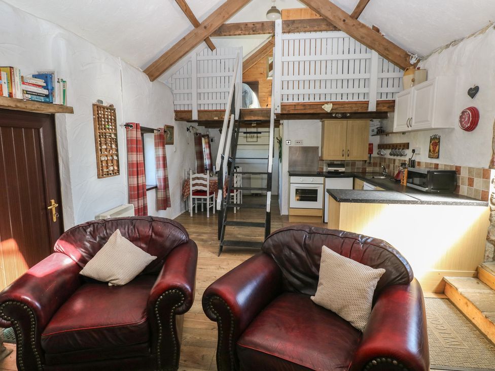 A living room with two armchairs and a staircase at Butterslade Port Eynon