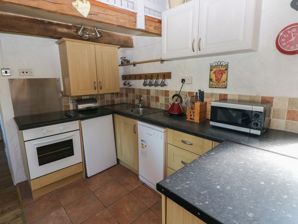 A kitchen with cabinets and appliances at Butterslade, Port Eynon