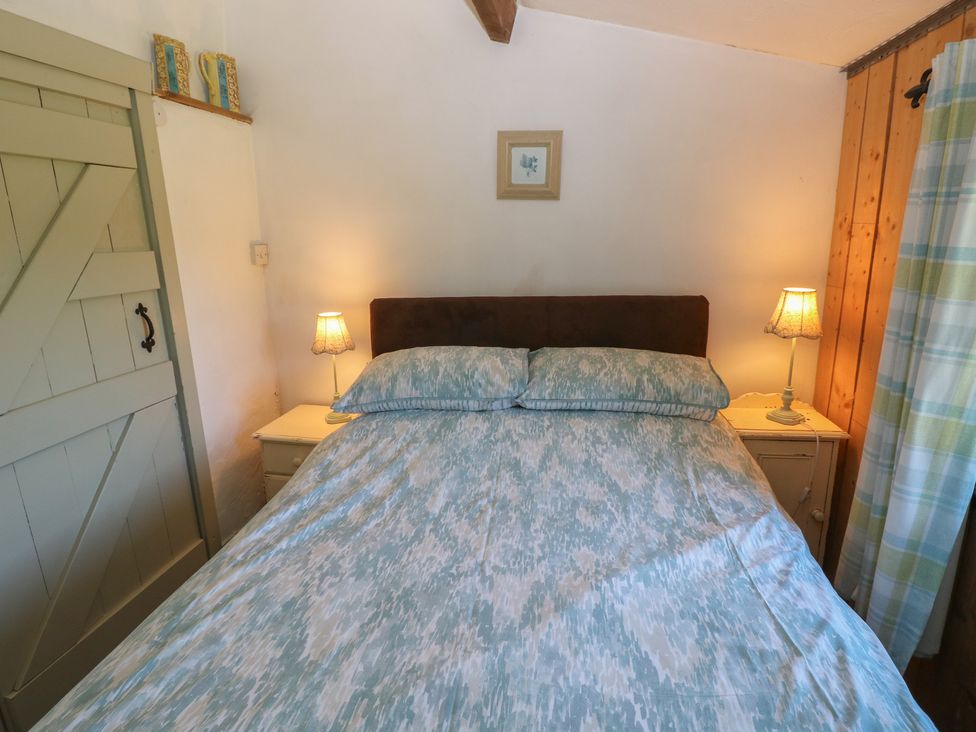 A bedroom with a bed and bedside tables at Butterslade in Port Eynon