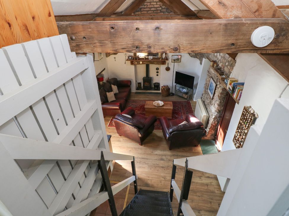 A living room with a sofa, coffee table, and television at Butterslade in Port Eynon