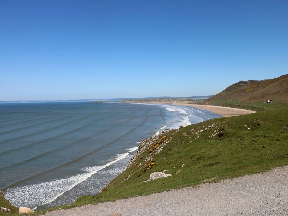 A beach view with sand and sea at Butterslade in Port Eynon