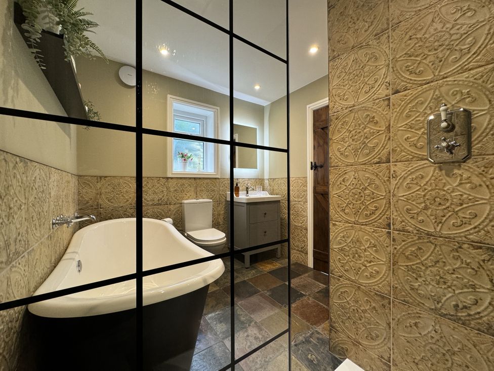 A bathroom with a bathtub, toilet, and sink at The Stables in Prestatyn
