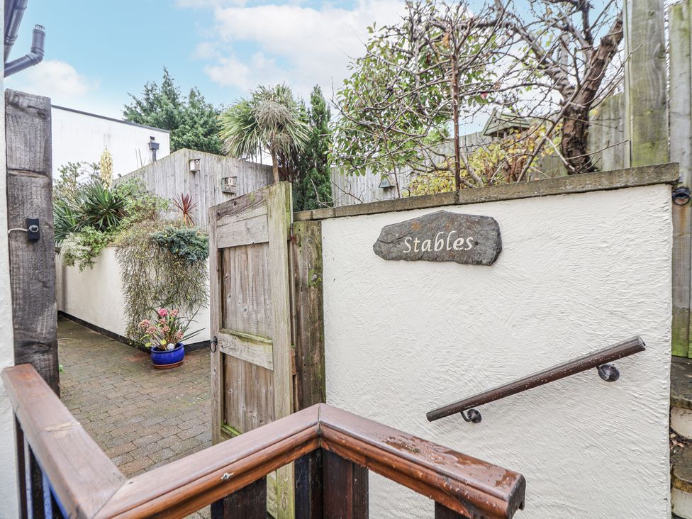 An outdoor pathway with a gate and a sign reading Stables at The Stables in Prestatyn