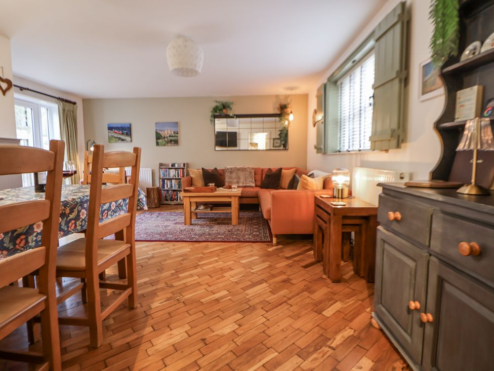 A living room with a sofa and dining table at The Stables in Prestatyn