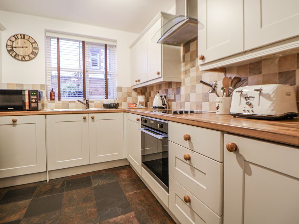 A kitchen featuring appliances and cabinets at The Stables in Prestatyn