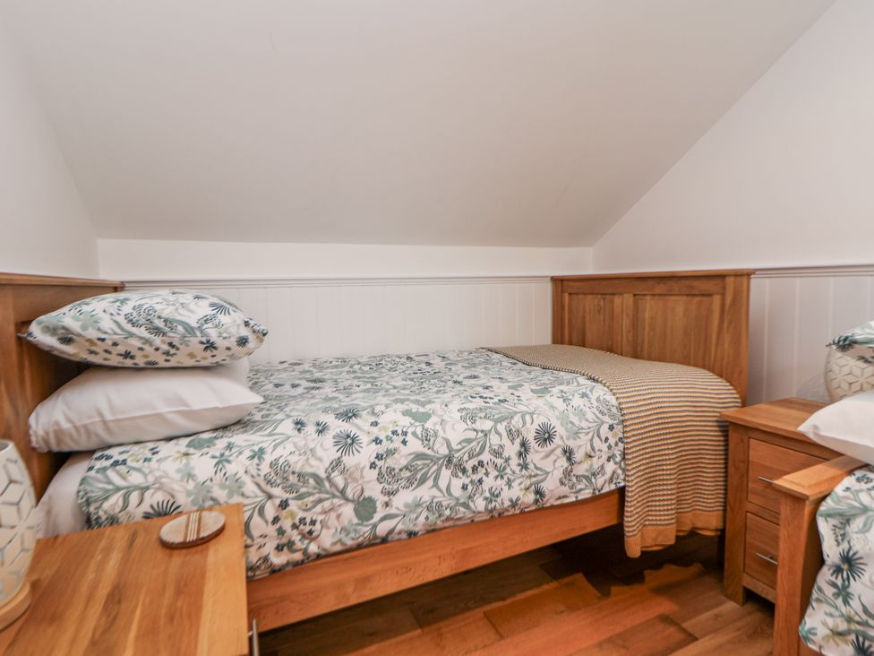 A bedroom with a bed and side table at The Stables in Prestatyn