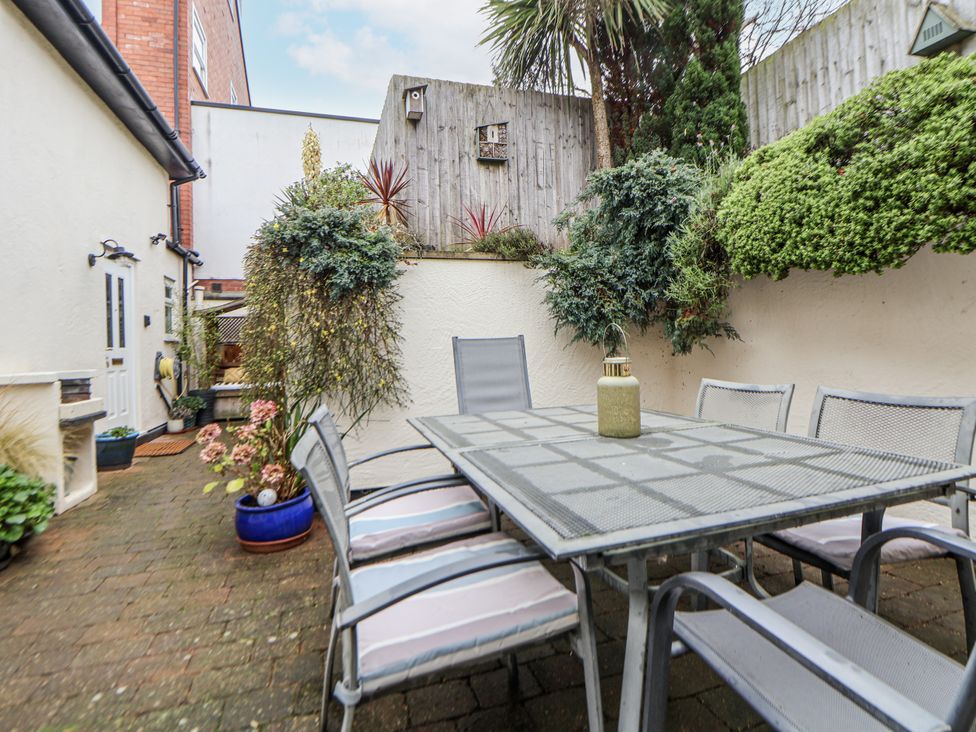 A garden with a table and chairs surrounded by plants at The Stables in Prestatyn