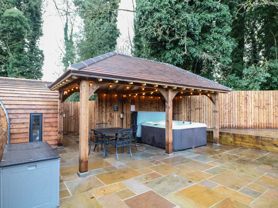 An outdoor area with a hot tub and seating at Park View Lodge
