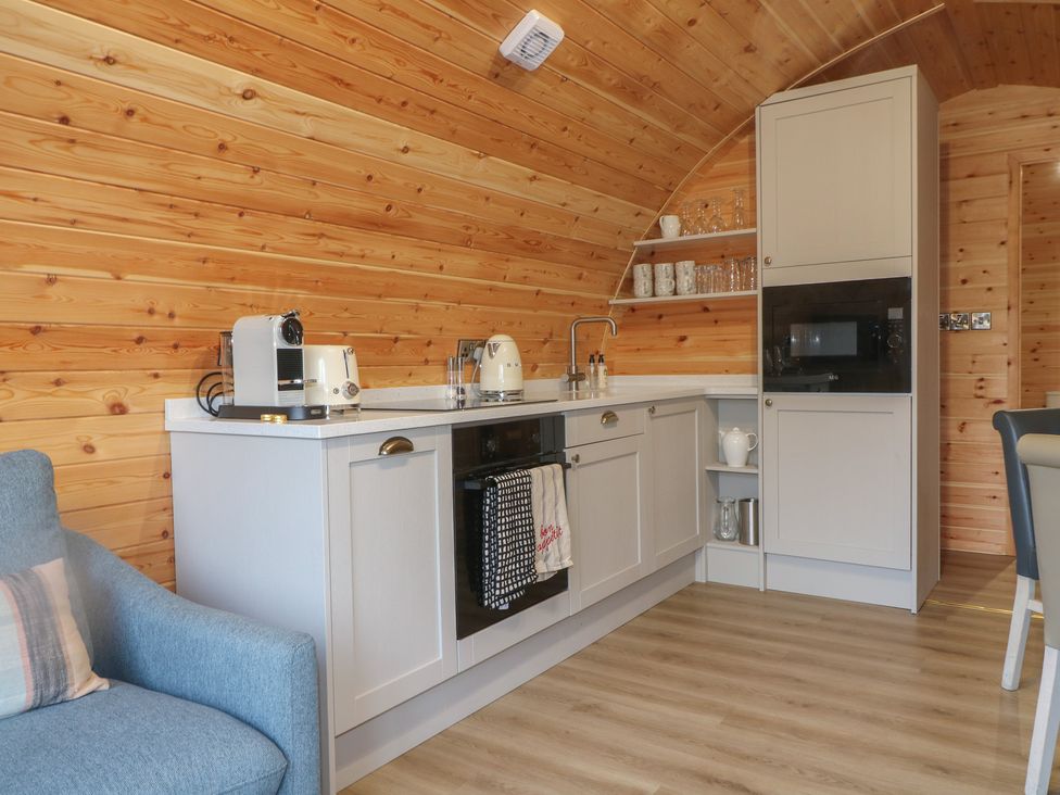 A kitchen with appliances and wooden walls at Park View Lodge