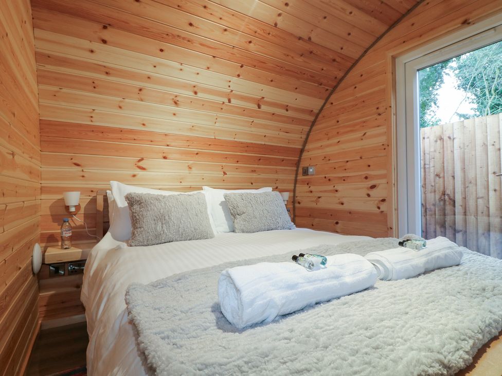 A bedroom with a bed and wooden walls at Park View Lodge