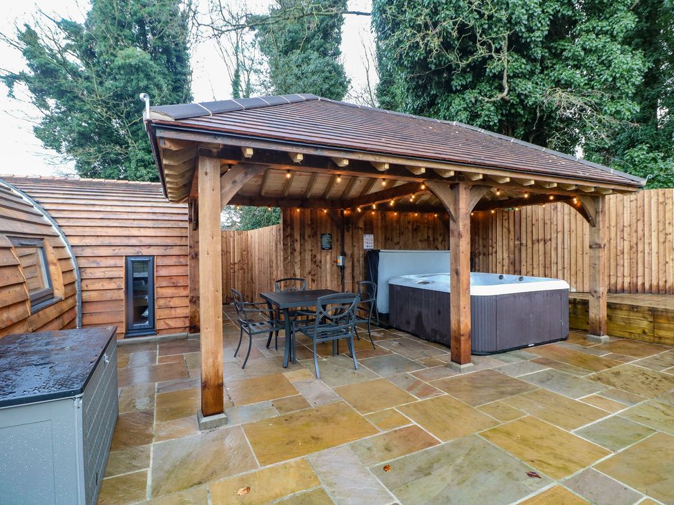 An outdoor area with a hot tub and seating at Park View Lodge