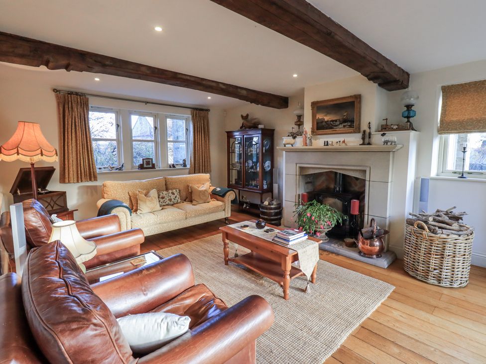 A living room with a fireplace and seating arrangements at Orchard House in Leyburn
