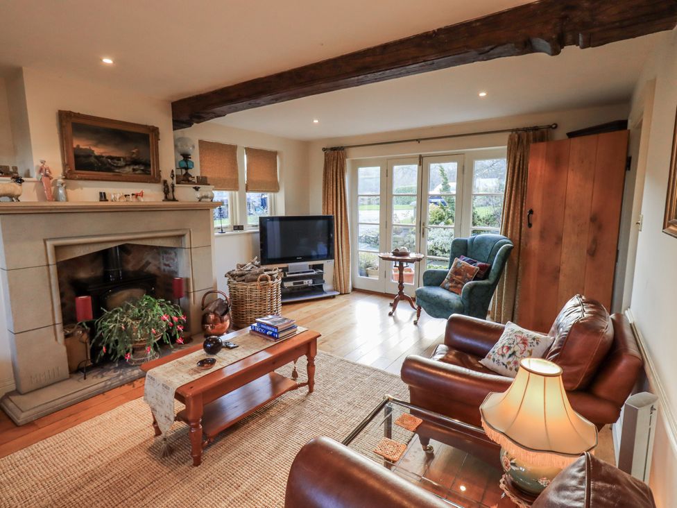 A living room with a fireplace and television at Orchard House in Leyburn