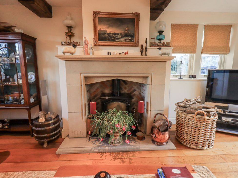 A living room with a fireplace and a television at Orchard House in Leyburn