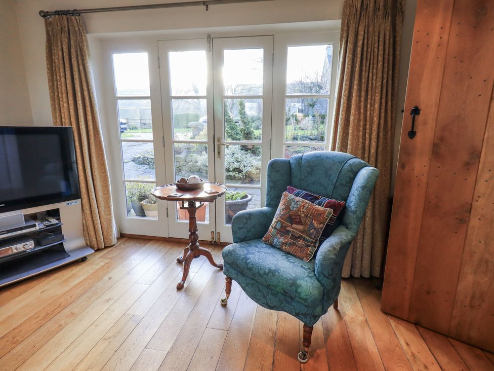 A living room with a chair and a television at Orchard House Leyburn