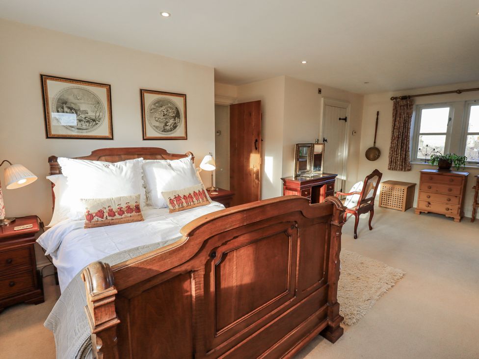 A bedroom with a bed, bedside tables, and a dresser at Orchard House Leyburn