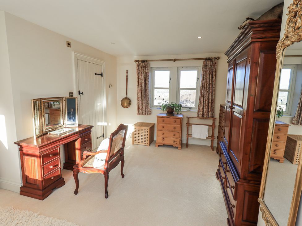 A bedroom with a vanity and wardrobe at Orchard House in Leyburn