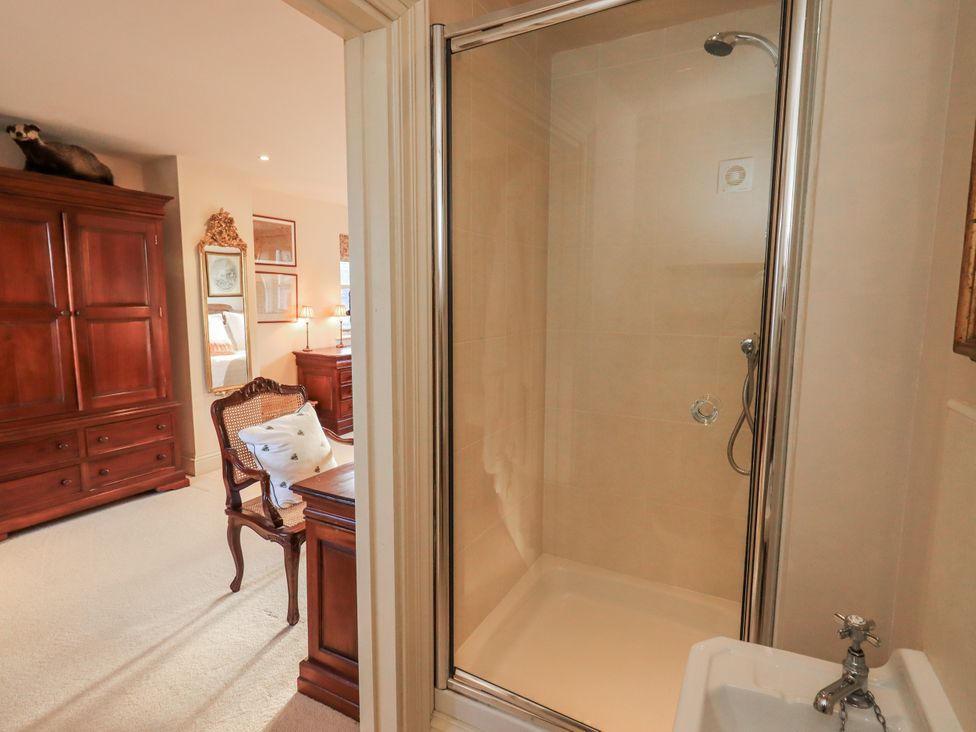A bathroom with a shower and a wardrobe at Orchard House in Leyburn