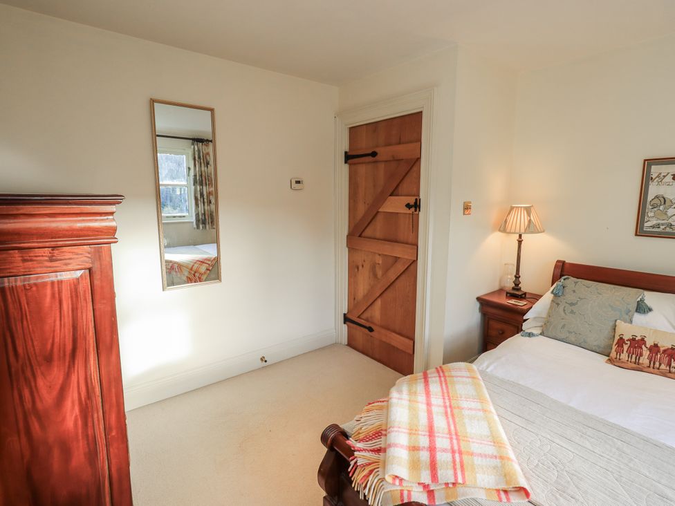 A bedroom with a bed and wardrobe at Orchard House in Leyburn