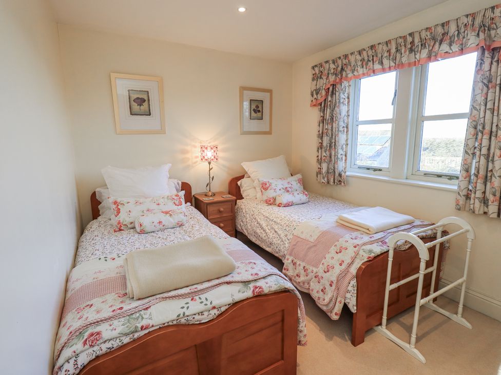A bedroom with two single beds and a bedside table at Orchard House in Leyburn