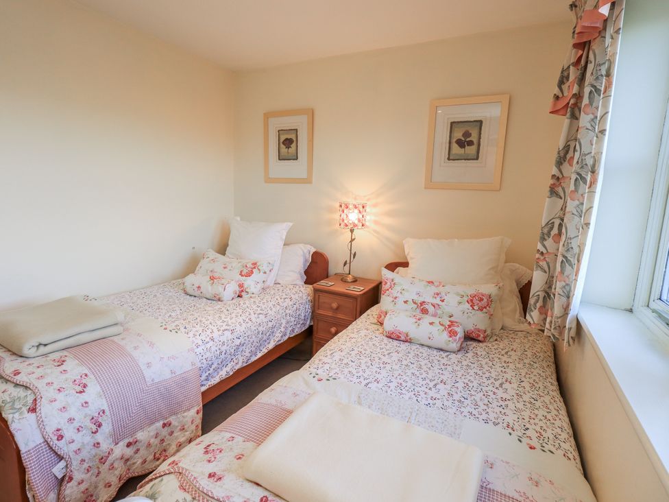 A bedroom with two single beds and a lamp at Orchard House Leyburn