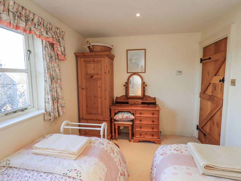 A bedroom with a bed, dresser, and wardrobe at Orchard House Leyburn