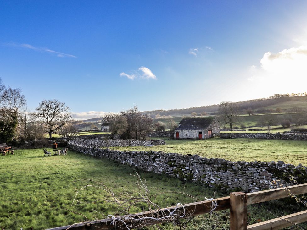 A house surrounded by stone walls and trees at Orchard House in Leyburn
