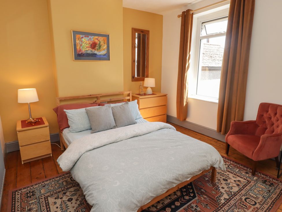 A bedroom with a bed and armchair at 18 Kent Street Cardiff