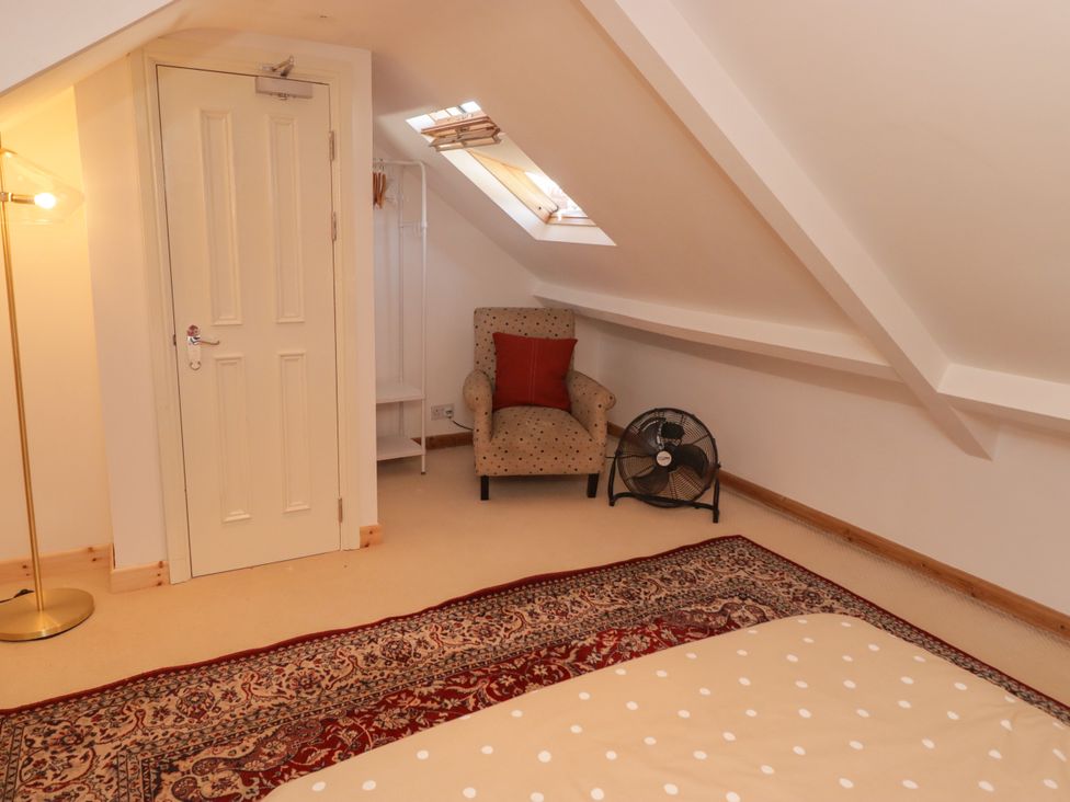A bedroom with a chair and shelf at 18 Kent Street in Cardiff