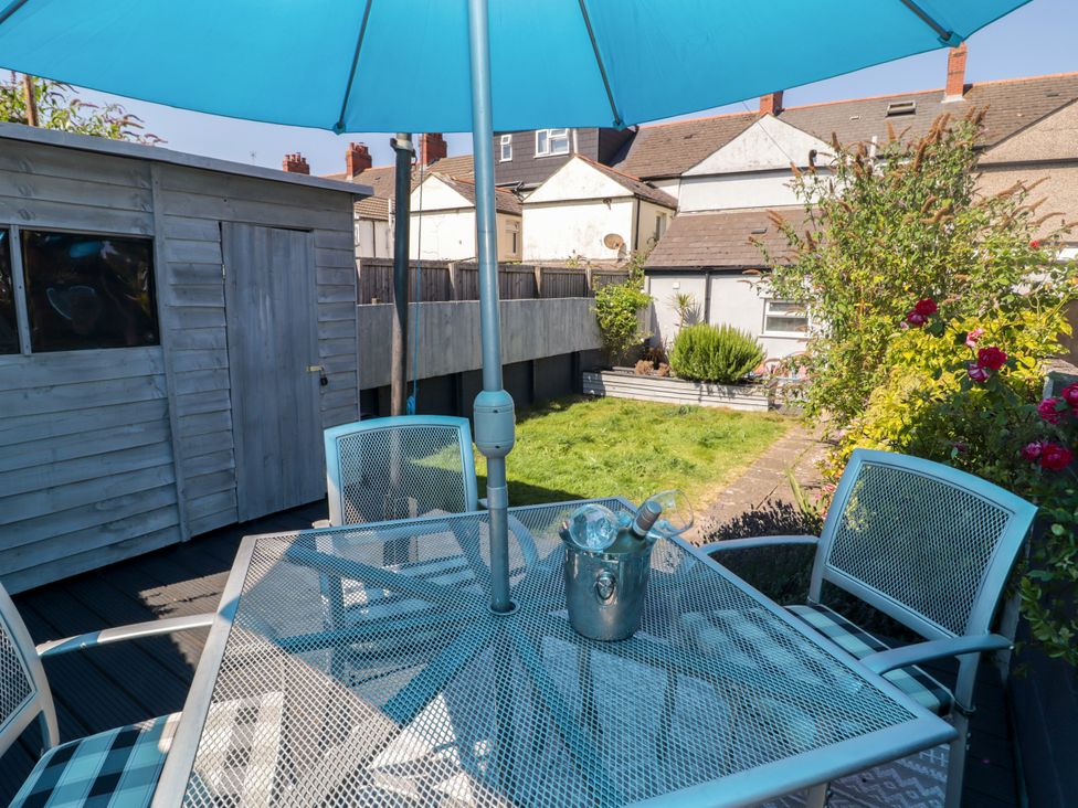 A garden with a table and chairs under an umbrella at 18 Kent Street Cardiff