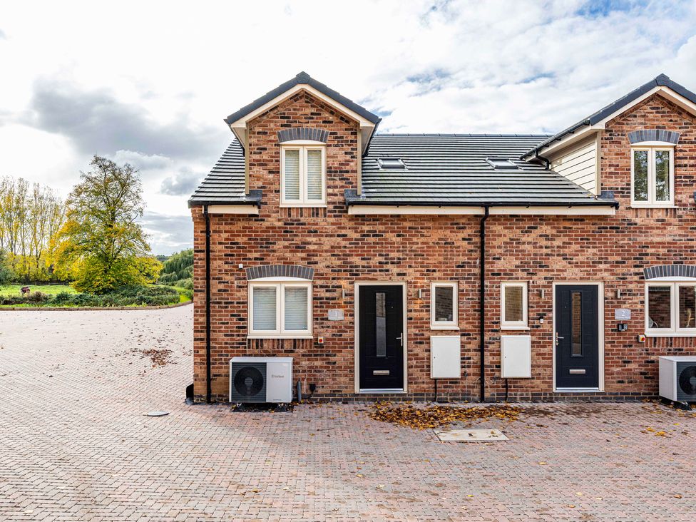 A brick house with multiple windows and doors at 2 Riverside Mews Derby