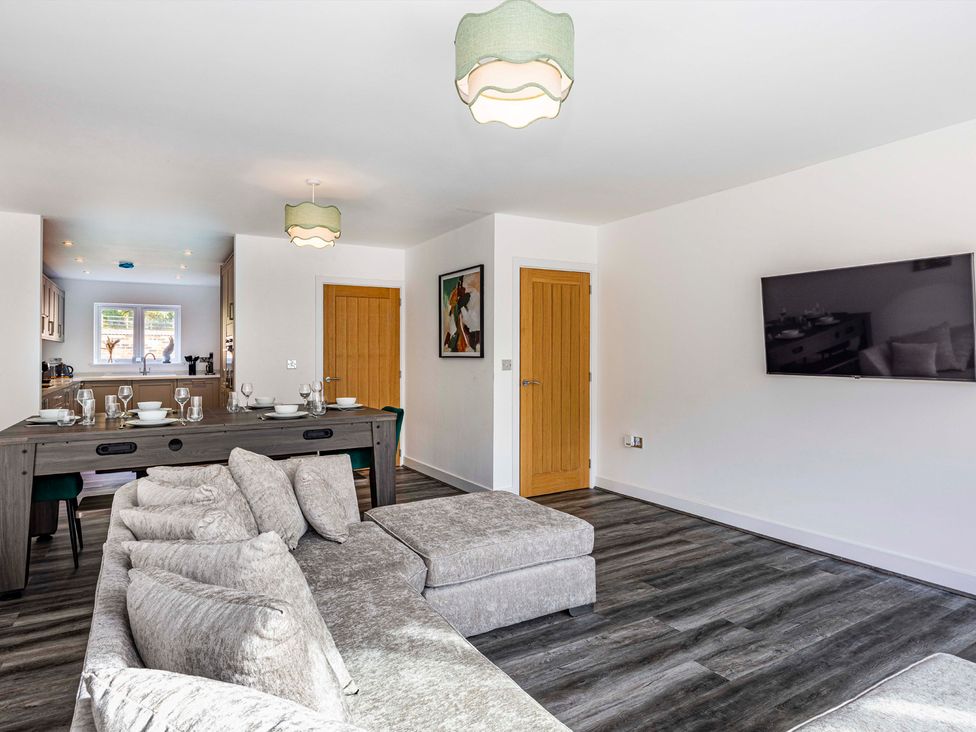 A living room with a sofa and dining table in 2 Riverside Mews Derby