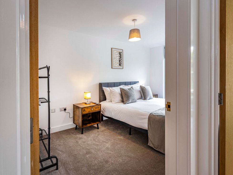 A bedroom with a bed and bedside table at 2 Riverside Mews Derby