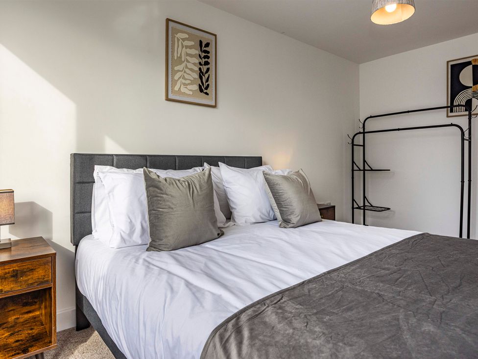 A bedroom with a bed and nightstand at 2 Riverside Mews in Derby