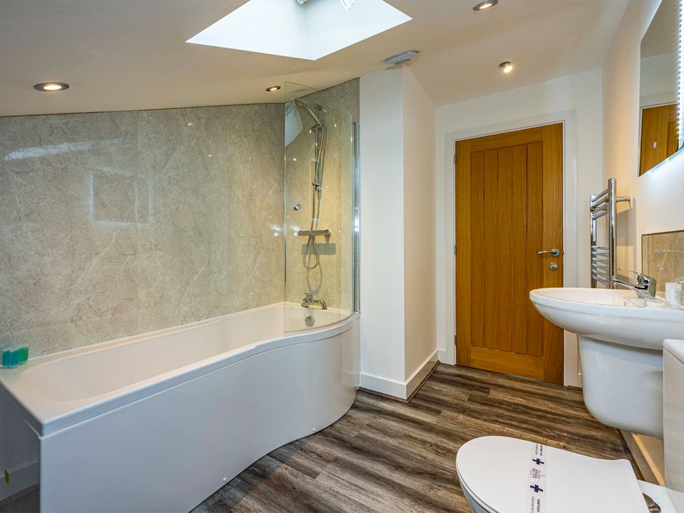 A bathroom featuring a bathtub, shower, toilet, and sink at 2 Riverside Mews in Derby