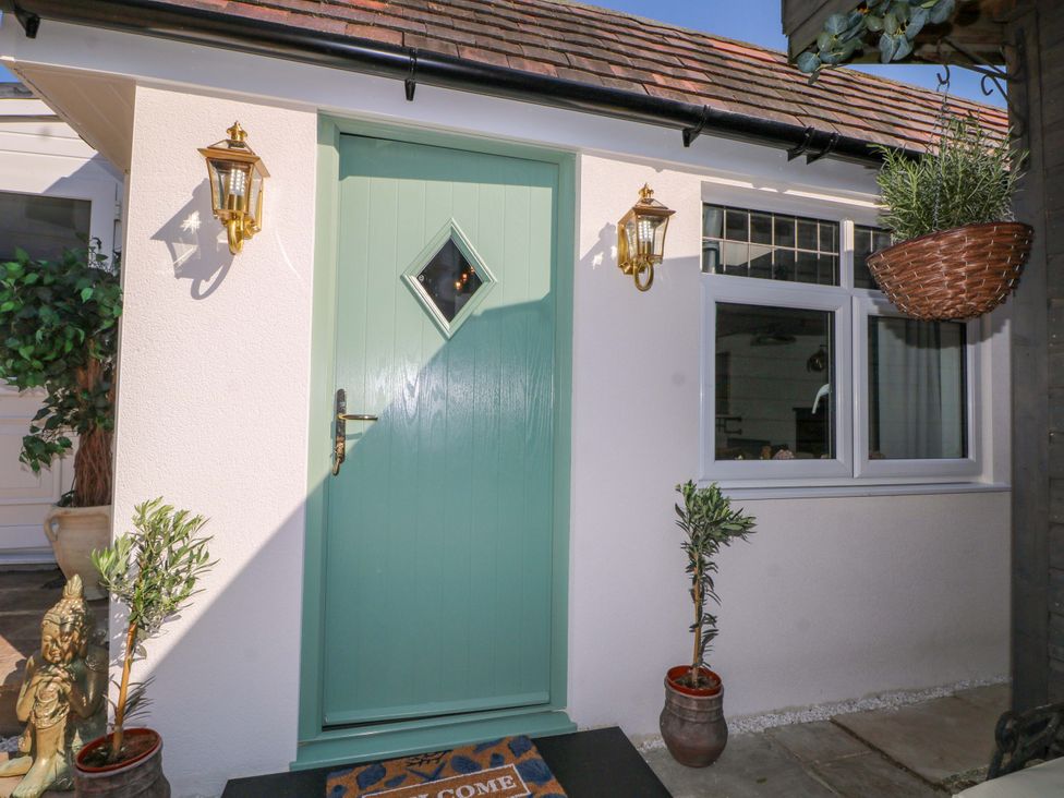 An entrance with a green door and potted plants at Shell Cottage in Bournemouth