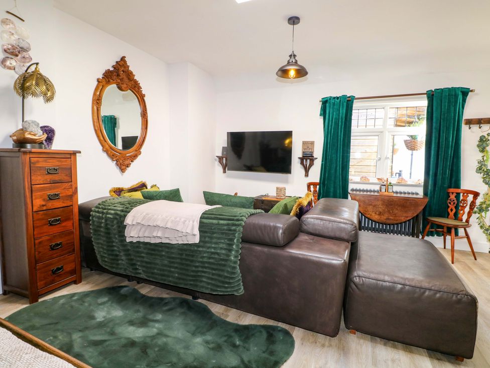 A living room with a sofa and television at Shell Cottage in Bournemouth