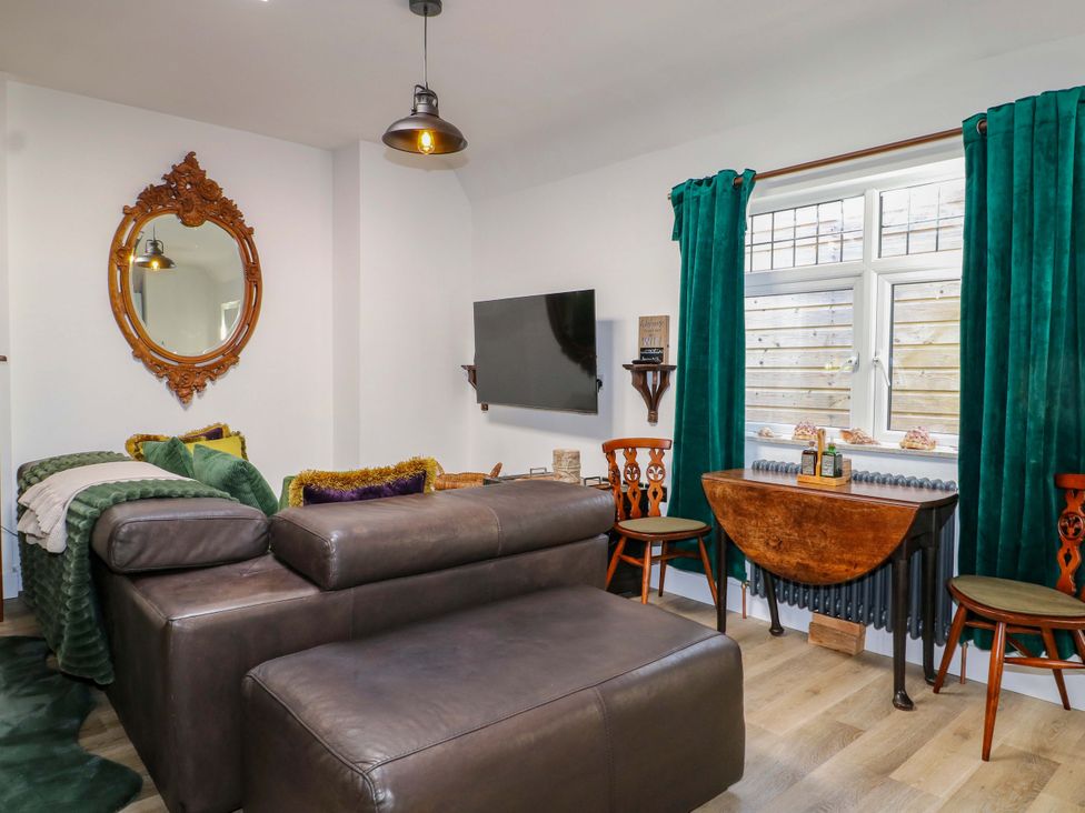 A living room with a sofa and television at Shell Cottage in Bournemouth