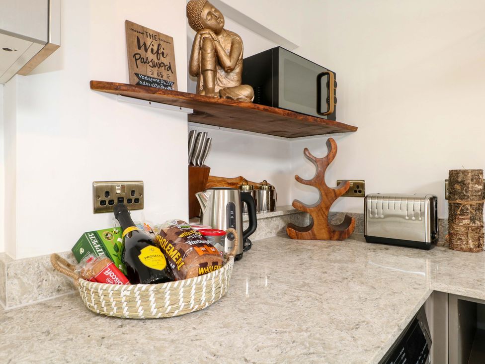 A kitchen counter with a kettle and a microwave at Shell Cottage in Bournemouth