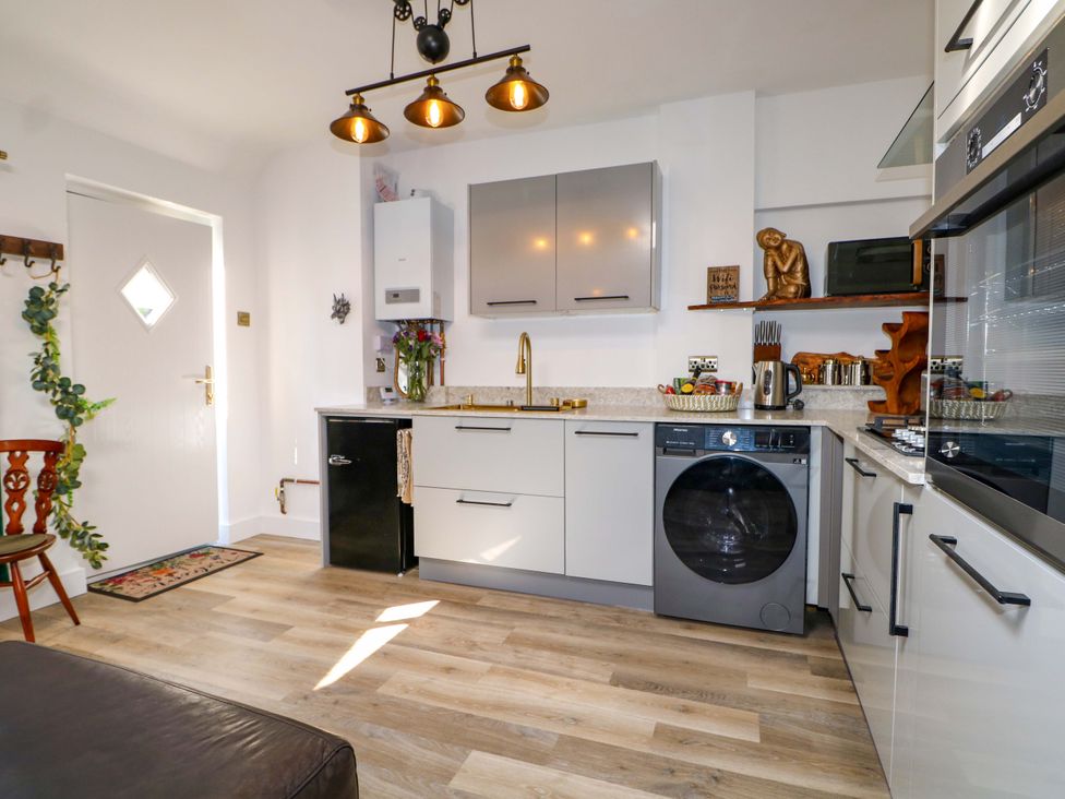 A kitchen with appliances and furnishings at Shell Cottage in Bournemouth