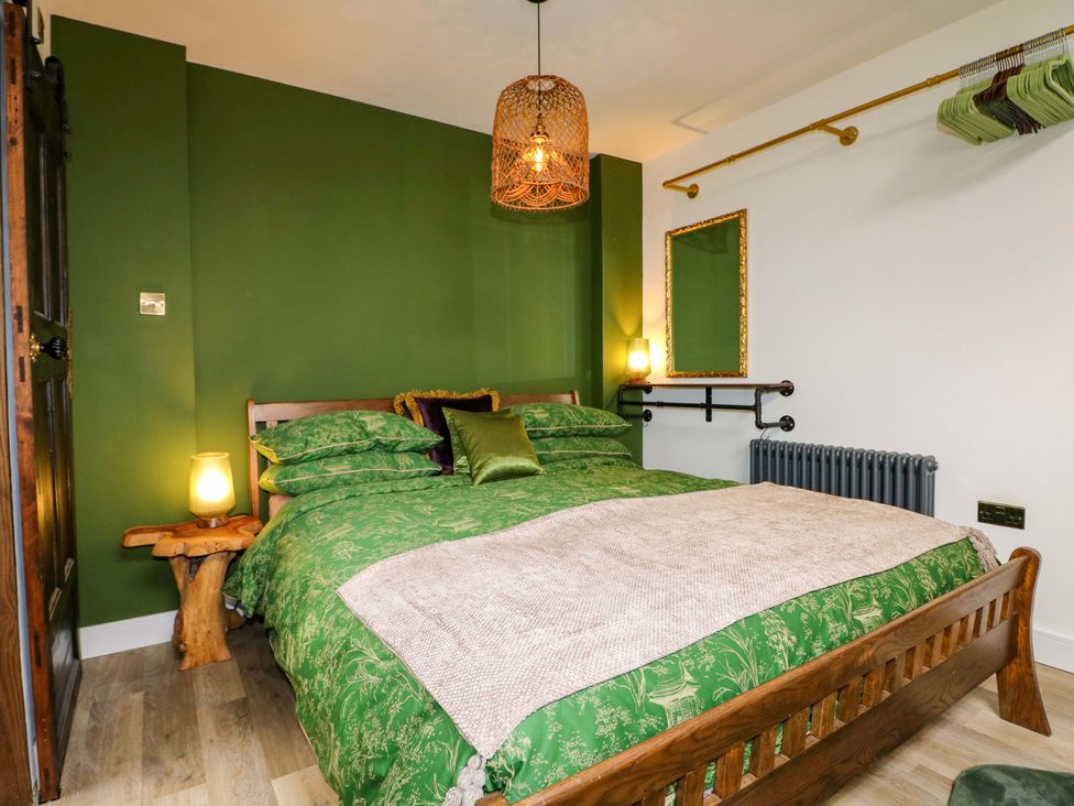 A bedroom with a bed and lamp at Shell Cottage in Bournemouth