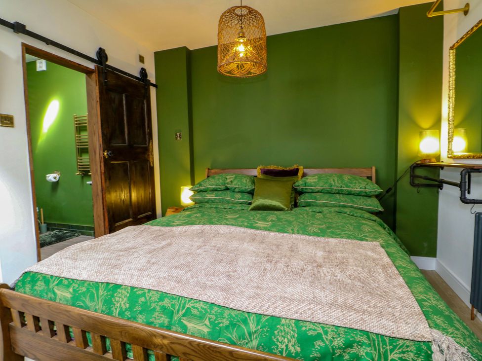 A bedroom with a bed and door at Shell Cottage in Bournemouth