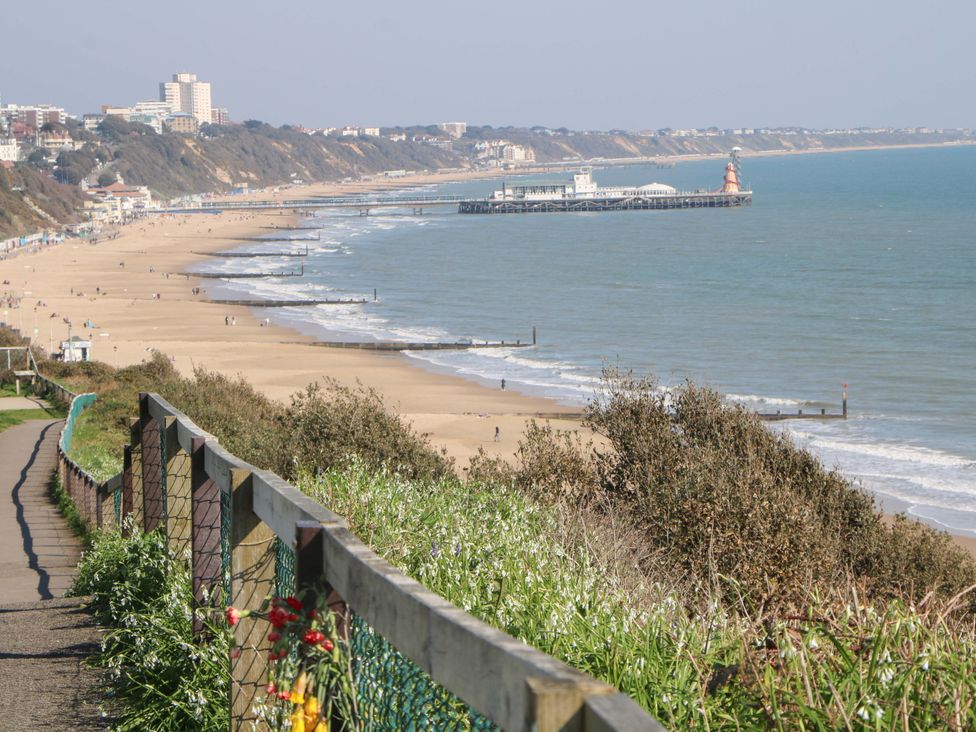 A beach view with a pier and walking path at Shell Cottage in Bournemouth